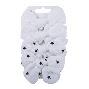 Detail of four-piece soft cotton baby hair clips with white and star patterns