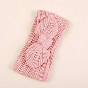 Détail de bandeaux en nylon jacquard rose montrant la texture du tricot et le grand nœud