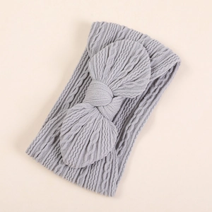 Détail d'un bandeau pour bébé en nylon gris clair avec nœud papillon et texture douce