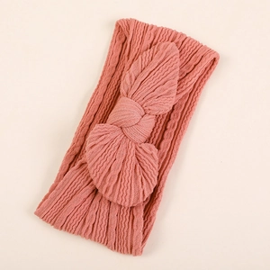 Gros plan du bandeau rose corail avec nœud en maille texturée douce pour bébés et enfants