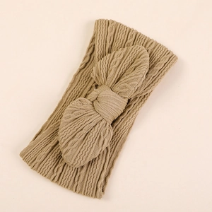 Détail d'un bandeau pour bébé en maille côtelée kaki avec un grand nœud décoratif