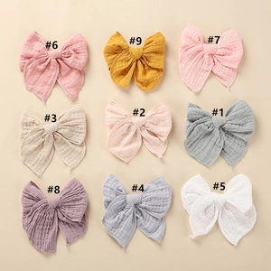 Selection of nine colorful cotton bow hair clips in pastel tones with ribbed texture