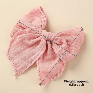 Detailed macro view of pink cotton linen bow hair clip with textured fabric edges