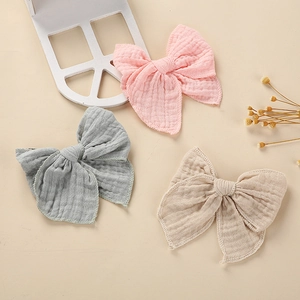 Three-piece set of cotton gauze bow hair clips for infants in pastel pink, grey, and beige