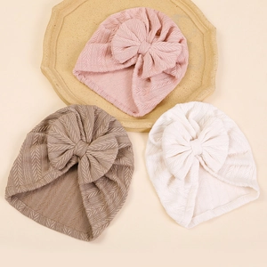 Three-piece set of textured baby turbans with bows in pink, brown, and white colors