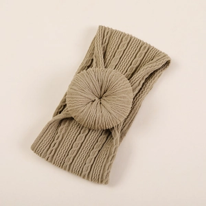 Détail macro du bandeau bébé kaki en tricot avec nœud donut et texture torsadée