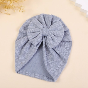Detailed close-up of wheat-patterned knit light blue baby turban hat with a large bow