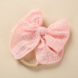 Detailansicht der weichen rosa Baumwoll-Musselin-Schleife mit flexiblem Baby-Stirnband