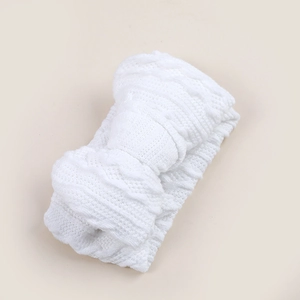 Gros plan d'un bandeau blanc pour bébé avec un grand nœud et une texture en maille douce