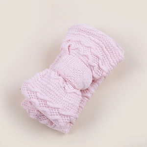 Vue détaillée du bandeau pour bébé en tricot rose avec un double nœud et texture gaufrée