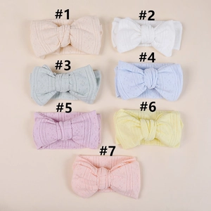 Flat lay of seven knit baby headbands with large bows and hollow mesh texture