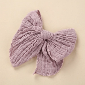 Detailed close-up of a light purple cotton bow hair clip featuring soft crinkle texture