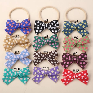 Set of 12 knitted baby bow headbands in various colors with soft nylon elastic bands