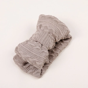 Détail de la maille torsadée douce sur le bandeau pour bébé à double nœud marron clair