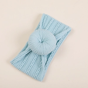 Détail d'un bandeau bébé bleu clair avec nœud donut doux et texture en maille torsadée