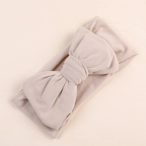 Close-up of soft beige milk silk fabric and large bow detail on baby headband