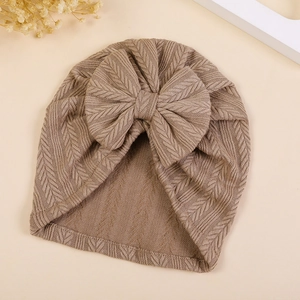 Detailed view of the textured herringbone knit pattern on this beige baby turban hat