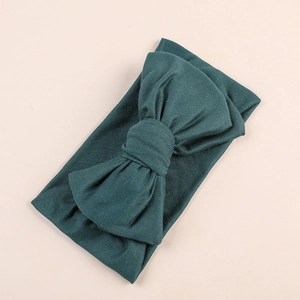 Detailed close-up of dark green soft milk silk baby headband with a large bow design