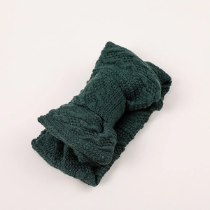 Gros plan sur la texture en tricot torsadé vert foncé pour bandeau hiver enfant