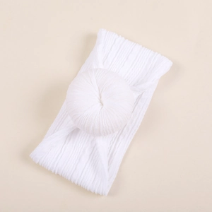 Détail d'un bandeau blanc doux pour bébé en tissu côtelé avec un nœud en forme de donut