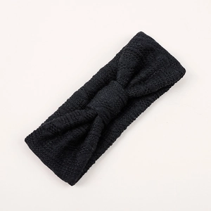 Gros plan du bandeau tricoté noir pour bébé avec un détail de nœud central décoratif