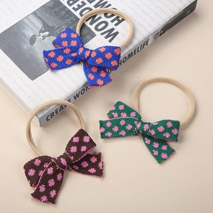 Detailed close-up of three knitted polka dot bow headbands with soft nylon bands for babies