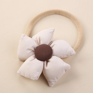 Détail d'un bandeau pour bébé en nylon avec fleur 3D en tissu beige et bouton central marron