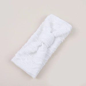 Gros plan d'un bandeau pour bébé en tricot blanc avec un grand nœud et maille ajourée