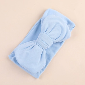 Detail of light blue baby headband with large oversized bow in soft knitted fabric