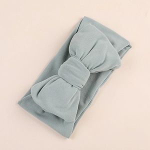Detailed close-up of a soft milk silk baby headband featuring a large olive green bow