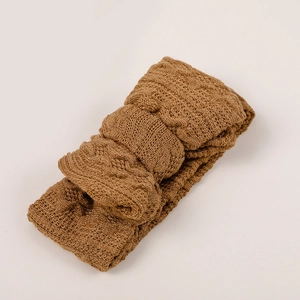 Détail d'un bandeau bébé marron avec texture classique en maille torsadée et tissu élastique