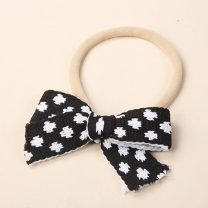 Close-up of soft knitted bow headband with black and white knit texture for babies
