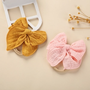 Detaillierte Nahaufnahme weicher Baby-Stirnbänder mit Baumwollschleife in Ingwer und Rosa