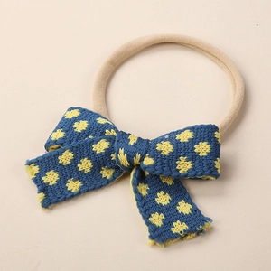 Detail of blue knitted baby headband with yellow floral pattern and soft nylon band