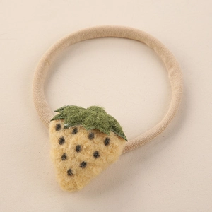 Détail de la breloque fraise en feutre sur bandeau élastique en nylon beige pour bébé