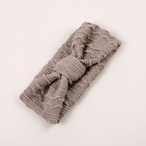 Détail d'un bandeau en tricot pour bébé avec nœud tressé en couleur mauve poussiéreux