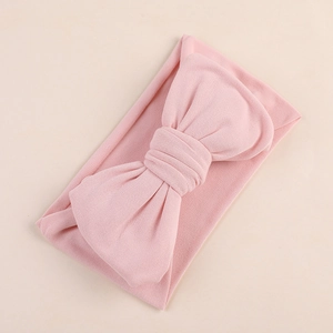 Detail of soft milk silk fabric texture on a large pink baby bow headband for infants