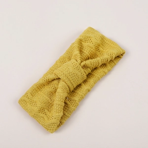 Détail montrant la texture en maille jaune moutarde et le nœud du bandeau bébé