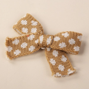 Dettaglio fiocco in maglia kaki con pois bianchi per accessori capelli per bambini