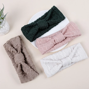 Détail de bandeaux tricotés pour bébé avec textures losanges et nœuds élégants