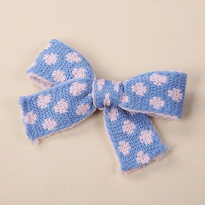 Dettaglio fermaglio per capelli a fiocco in maglia blu con motivo floreale rosa