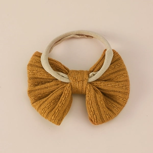 Soft nylon baby headband with a mustard yellow jacquard knit bow for infants