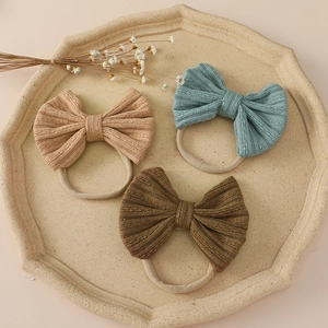 Detailed view of three-piece jacquard bow headbands in soft Morandi knit texture