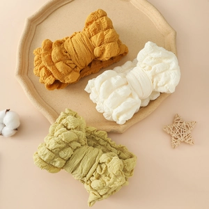 Trois bandeaux pour bébé en tissu gaufré aux tons jaune, crème et vert d'eau