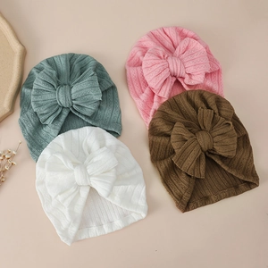 Detail of ribbed texture and soft fabric bows on four colored baby turban hats