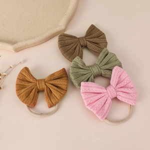 Detail of four jacquard bow headbands in soft nylon for infants and toddlers