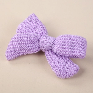 Detailed view of handmade knitted lavender bow hairclip with 3D honeycomb texture