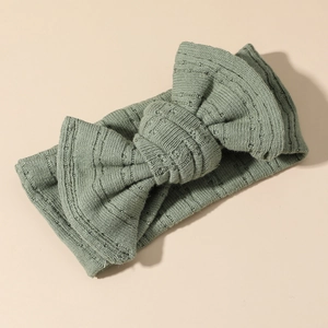 Dettaglio della fascia in maglia verde salvia con fiocco e morbida trama a coste