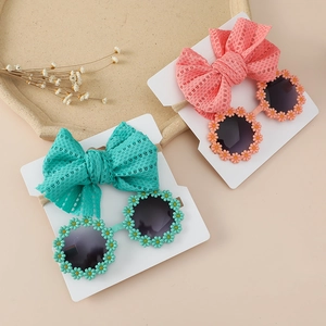 Detail view of baby daisy sunglasses and hollow mesh bow headbands in mint and coral