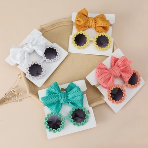 Detail of four colorful daisy sunglasses and matching lace bow headbands for toddlers